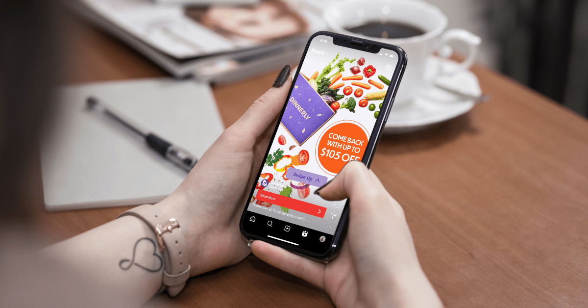A woman is holding a phone with an ad on Instagram for a food app on it to show the meaning of human-centric design